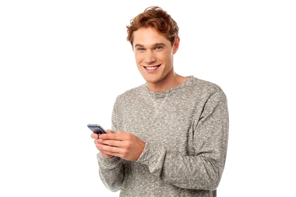 Feliz joven usando el móvil — Foto de Stock