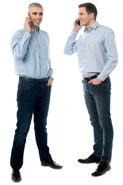 Two young men talking through mobile phone — Stock Photo, Image