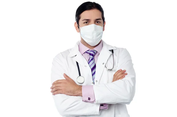 Young male doctor in a mask, arms crossed — Stock Photo, Image