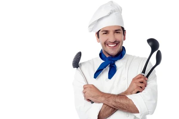 Chef sorridente segurando utensílios de cozinha — Fotografia de Stock