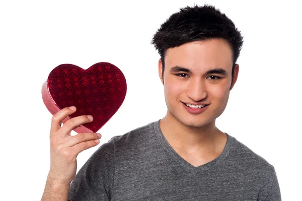 Young man holding heart shaped box — Stock Photo, Image