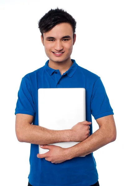 Mladý usměvavý chlap hospodářství laptop — Stock fotografie