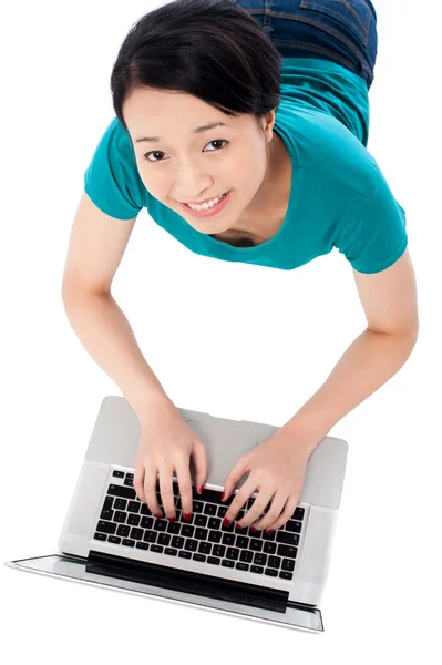 Mujer joven acostada en el suelo usando el ordenador portátil —  Fotos de Stock