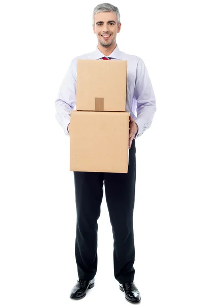 Smiling corporate man holding stack of boxes — Stock Photo, Image