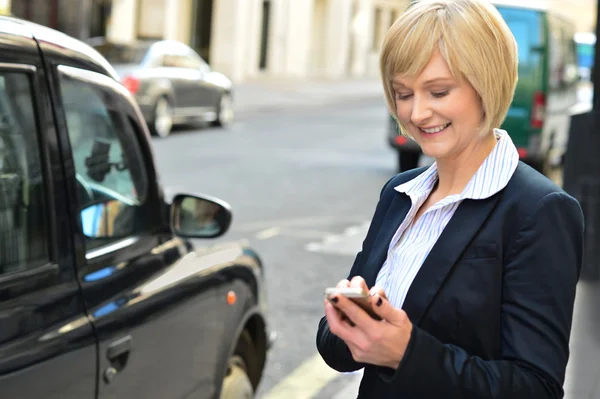 Mosolyogva Közép idősebb nő használ sejt telefon — Stock Fotó