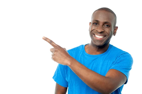 Smiling casual man pointing away — Stock Photo, Image