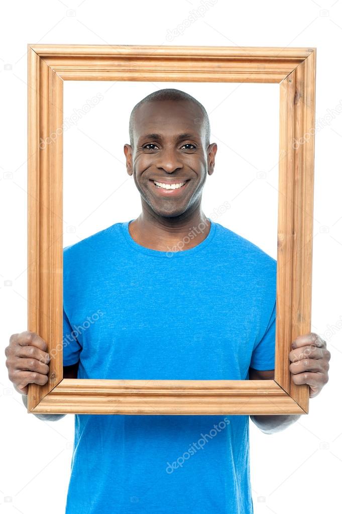 Man behind wooden picture frame