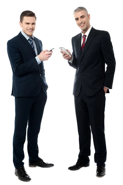 Glimlachende zakenmensen met behulp van mobiele telefoon — Stockfoto