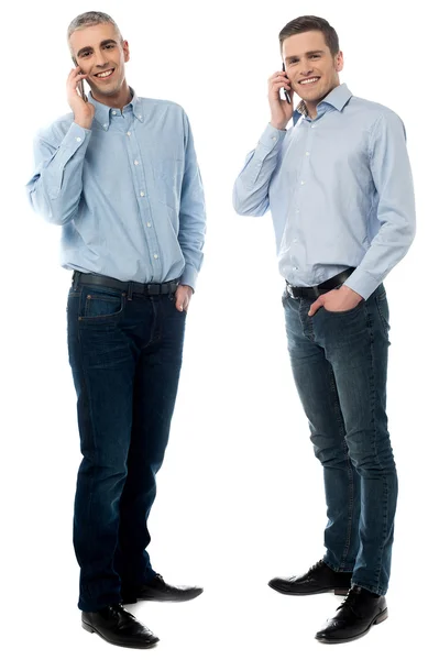 Δύο νεαροί άνδρες που μιλάει μέσα από το κινητό τηλέφωνο — Φωτογραφία Αρχείου