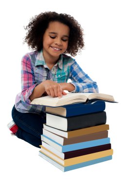 Kız diz çökmüş ve kitap okuma