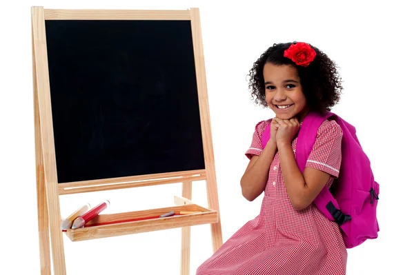 Schulkind sitzt neben Tafel — Stockfoto