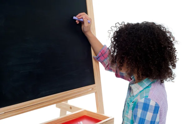 Mädchen schreibt auf Klassenzimmertafel — Stockfoto