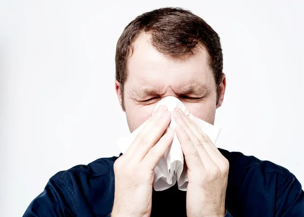 Uomo che si soffia il naso in un tessuto — Foto Stock