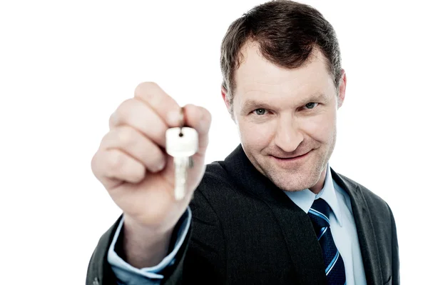Бизнесмен держит ключ от дома — стоковое фото