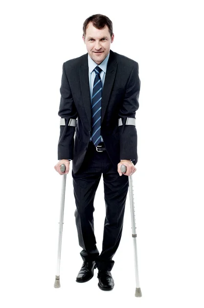 Businessman with crutches trying to walk — Stock Photo, Image