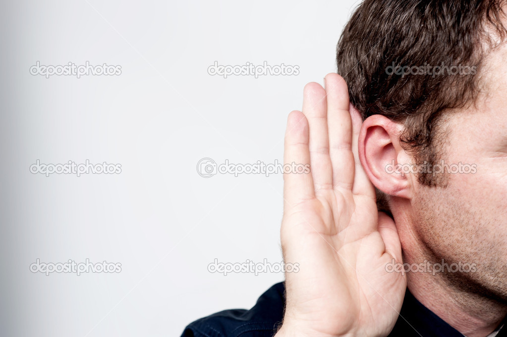 Man holds his hand near his ear