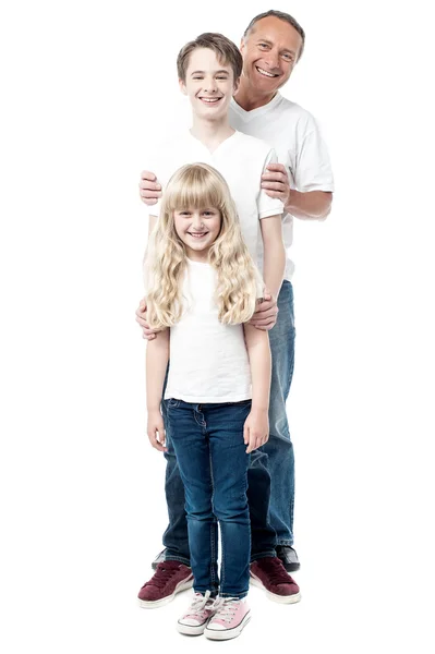 Smiling father with children standing in a row — Stock Photo, Image