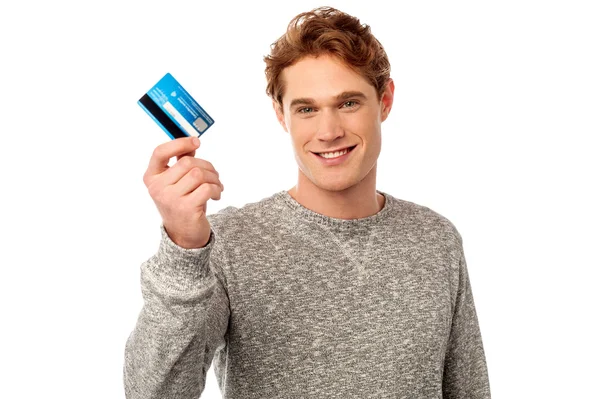 Jovem sorridente segurando cartão de crédito — Fotografia de Stock