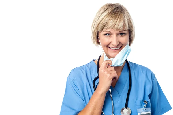 Lady doctor removing surgical mask — Stock Photo, Image