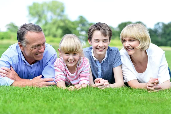 Famille de quatre personnes se relaxant dans le parc — Photo