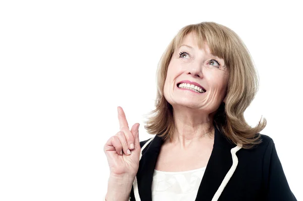 Smiling woman pointing upwards — Stock Photo, Image