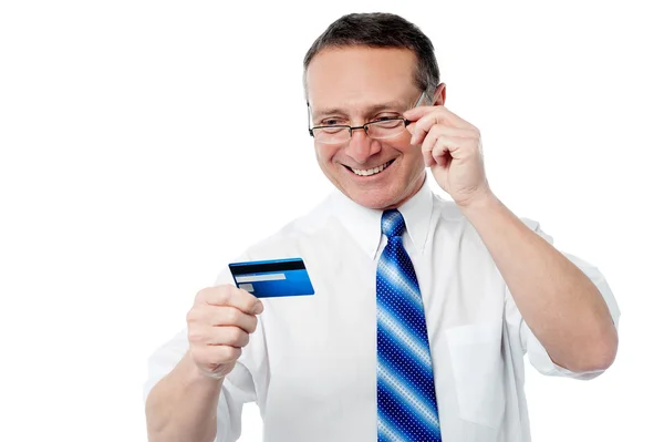 Улыбающийся руководитель держит кредитную карту — стоковое фото