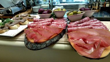 Tahtalar jambon ve salam dolu. Zeytin ve kırmızı soğan. 
