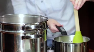 Yemek hazırlıyorum. Eller tencerenin içindekileri kaşıkla karıştırıyor..