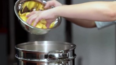 Yemek hazırlıyorum. Eller tavaya erişte koyuyor..