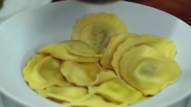 Yemek hazırlıyorum. Eriştenin üstüne pesto koymak. Seçici odak.