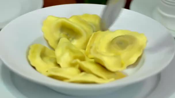 スプーンで麺を攪拌 白い皿の上のラビオリパスタ — ストック動画