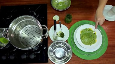 Pişmiş makarna ile tabağa pesto sosu döküyorum. Lezzetli bir yemek pişiriyorum. İtalyan mutfağı.