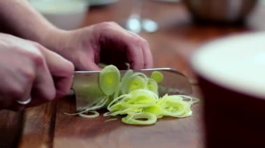 Yemek hazırlıyorum. Pırasa kesen bıçaklı eller. İçindekiler hazırlık konsepti.