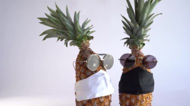 Gözlüklü ve maskeli ananas. Küresel etki kavramı COVID-19.