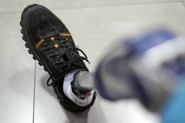 Mekanik bir bacakla devre dışı bırakılmış. Protezde siyah spor ayakkabılar.