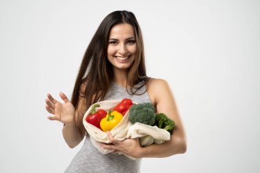 Gülümseyen güzel bir kızın portresi alışveriş için ağ torbası kullanıyor. Bilinçli tüketim. Çevre trendi. Sıfır atık. Elbiseli kız çanta satıcısı..