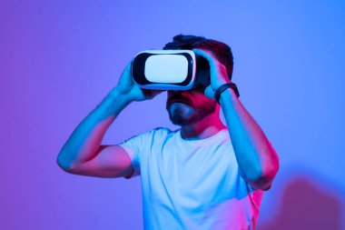 Modern stüdyoda sanal gerçeklik gözlüğü takan genç adamın yakın çekim. Vr kulaklıkla akıllı telefon kullanma.