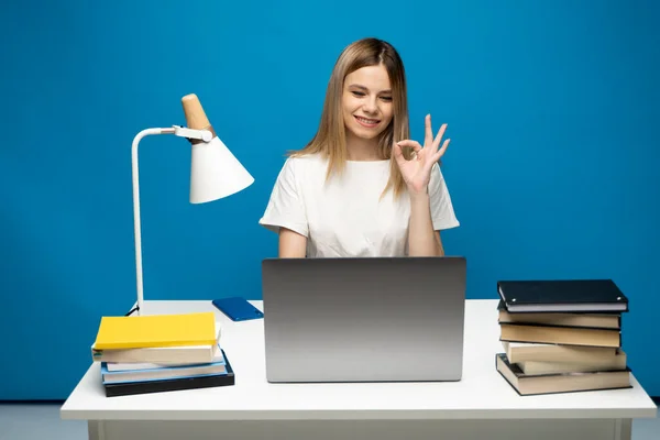 Szczęśliwa kobieta za pomocą laptopa i pokazując ok znak do znajomych, współpracowników lub klientów, że wszystko jest ok i patrząc na ekranie komputera. — Zdjęcie stockowe
