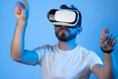 Genç adam tasarımcı veya mimar VR kulaklık kullanarak sanal gerçeklik deneyimi yaşıyor.
