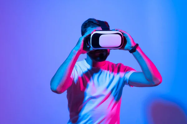 Joven con barba utiliza gafas de realidad virtual para comunicarse con un amigo en metáfora. Realidad aumentada, ciencia, concepto de tecnología futura, realidad virtual. — Foto de Stock