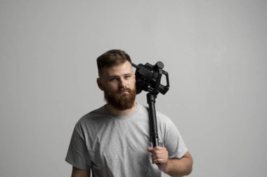 Profesyonel görüntü yönetmeni kamerayı 3 eksenli dingilde tutuyor. Steadicam kullanan bir kameraman. Pro ekipmanlar titremeden yüksek kaliteli video yapmaya yardımcı olur.