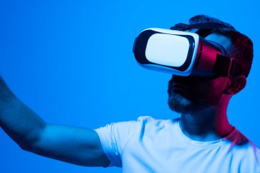 Adam VR kulaklık kullanıyor. Gelecek teknolojisi, çevrimiçi oyun, sanal gerçeklik, eğlence, çalışma, 3 boyutlu simülasyon ve sanal dünya.