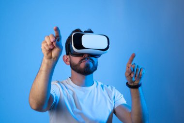 VR gözlük takan ve sanal gerçeklikle etkileşimde bulunan beyaz bir adamın portresi. Gelecekteki teknoloji konsepti.