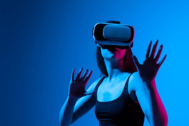 VR kulaklıklı kadın sanal gerçeklikteki nesnelere oyun oynarken ya da 3D film izlerken bakıyor. Gelecekteki teknoloji konsepti.