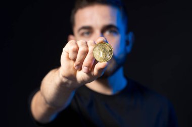 Altın Bitcoin bir iş adamının elinde. Yeni sanal para biriminin dijital sembolü. İnsan bitcoin tutar.