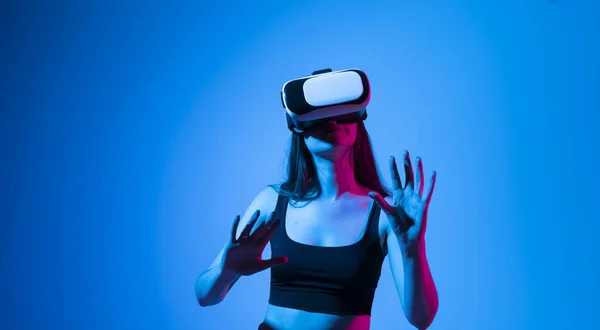 Barna nő VR headset megérint valamit, amit lát a virtuális világban. Futurisztikus technológia. Egy nő a virtuális valóság szemüvegével. Jövőbeli technológiai koncepció. — Stock Fotó