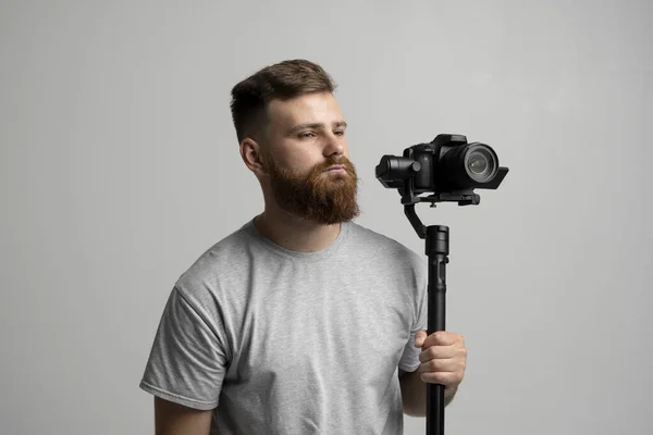 Bearder profesjonalny operator z 3-osiową kamerą gimbal i wideo na białym tle. Koncepcja produkcji filmowej, wideo, hobby i kreatywności. — Zdjęcie stockowe