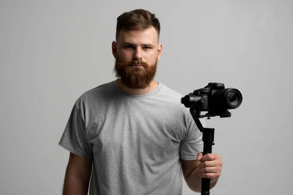 Videógrafo profissional usando câmera dslr no estabilizador gimbal isolado em fundo branco. — Fotografia de Stock