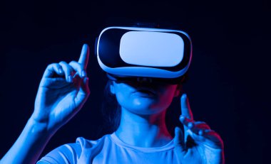 Dijital yenilik teknolojisi konsepti. Renkli neon ışıklarda VR gözlük kullanan ve eğlenen bir kadın. Giyilebilir sanal artırılmış gerçeklik.
