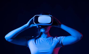 Genç kadın geliştirici, tasarımcı ya da mimar VR kulaklığı kullanarak VR teknolojisini kullanarak yeni bir ürün ya da teknoloji tasarlıyor. Gelecekteki teknoloji konsepti.